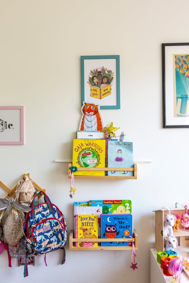 IKEA spice racks used as bookshelves for kids book. Hanger to the side is used to hold girls bags