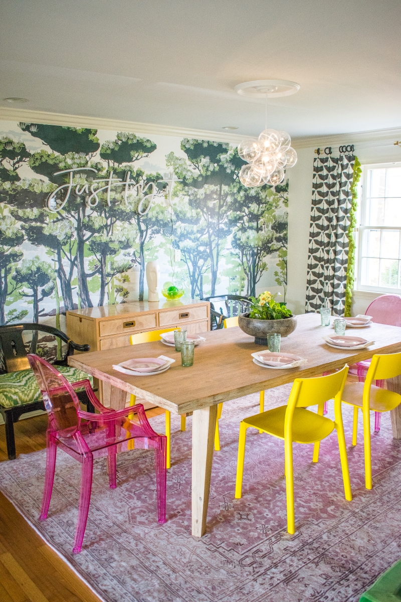 Dining room table in the living room with pink and yellow chair