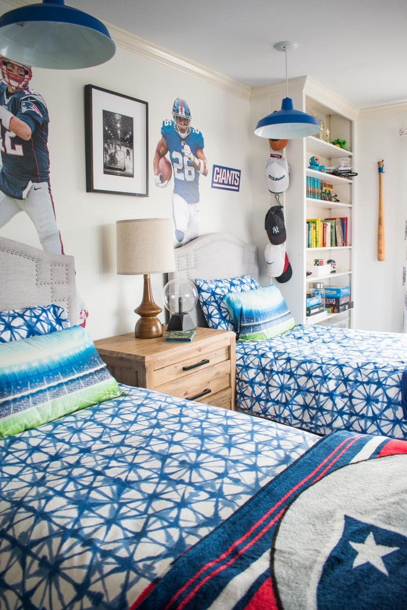 Boys bedroom with two beds and sports decor on the wall