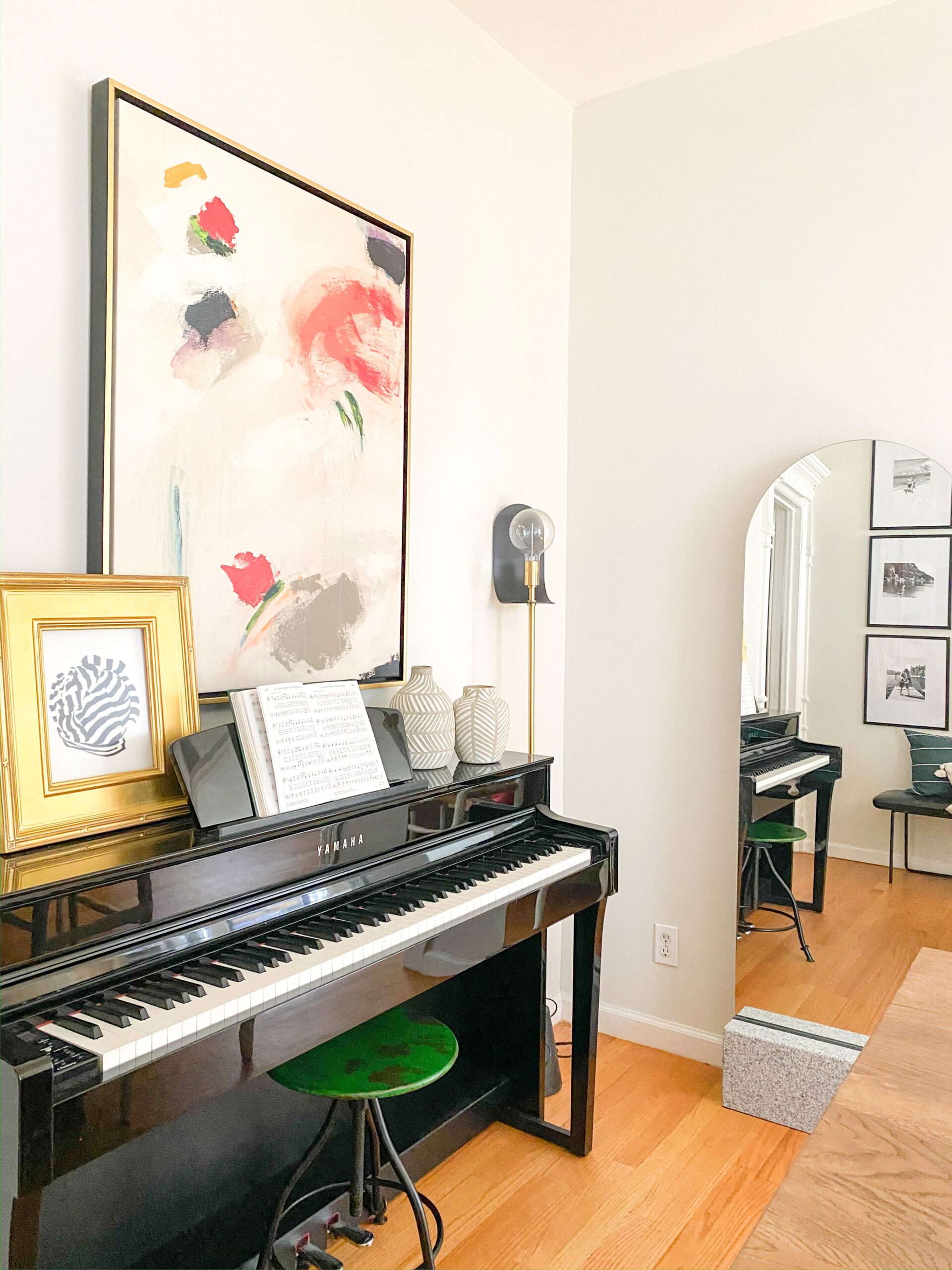 Black piano in the dining room with large art above it