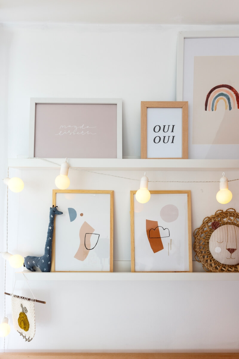 Minimal art in frames, on open shelving and string lights in a powdered style bulbs